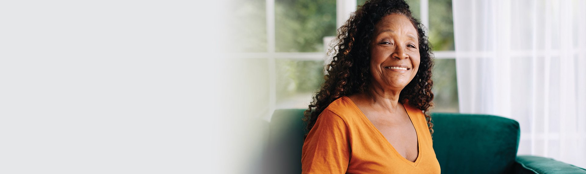 senior woman smiling wearing an orange shirt
