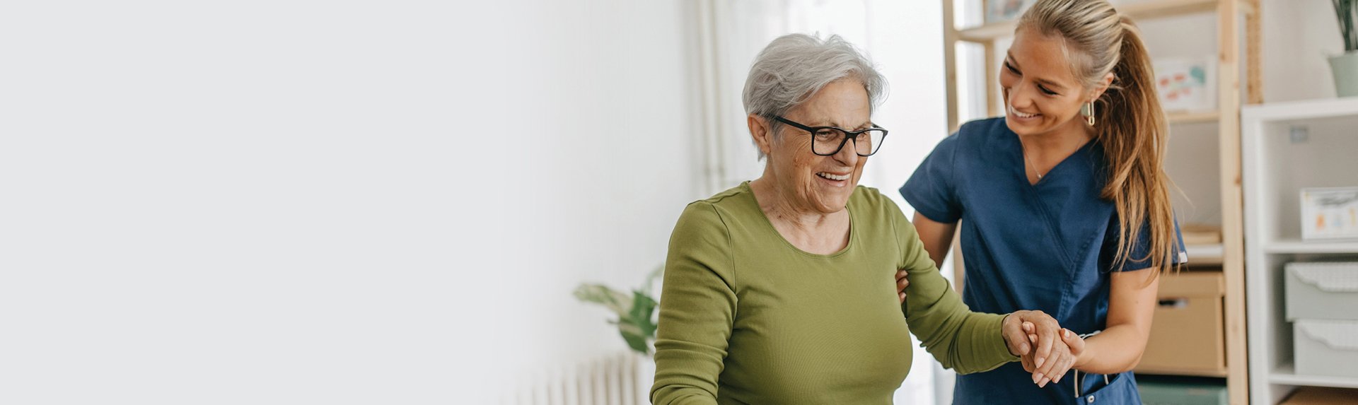female nurse helping a senior woman stand up