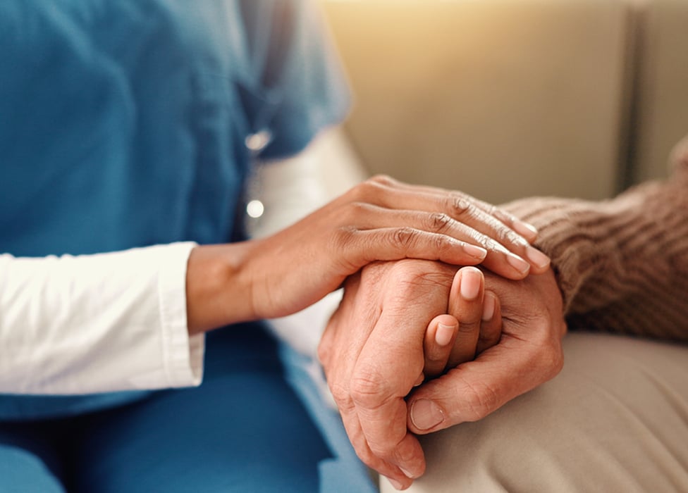 female nurse holding a senior man's hand
