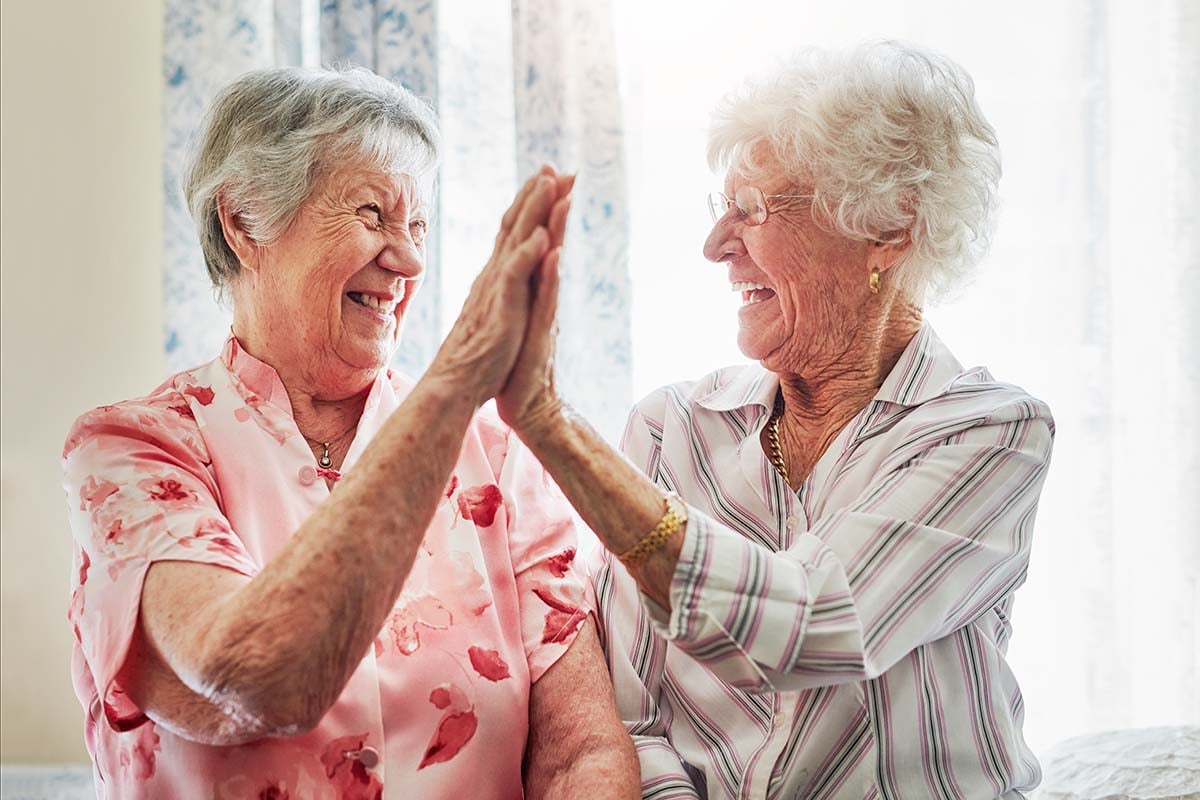 two senior women high fiving