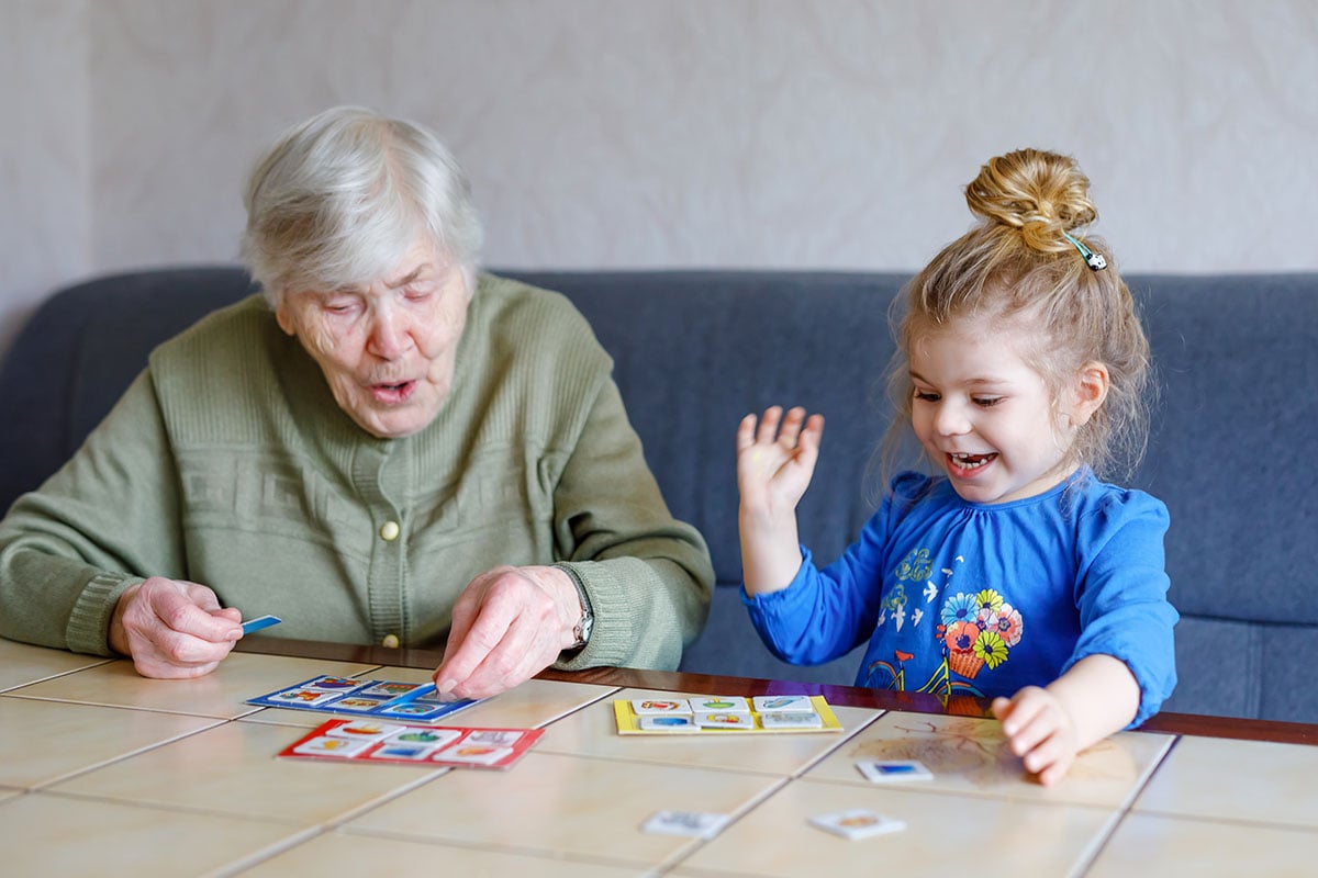 senior woman doing a puzzle with younger girl